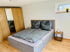 a bedroom with a bed with a headboard and pillows at Auszeit im Grünen, ideal für Ausflüge ins Legoland, Allgäu oder Skylinepark in Waltenhausen