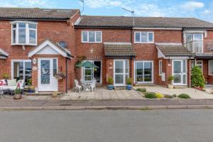 a brick house with a patio in front of it at 2 Bed in Reedham oc-c29528 in Haddiscoe
