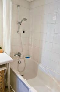 a bath tub with a shower in a bathroom at [Chalet] Studio Premium, WIFI, Chaleureux in Lourdes