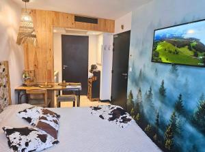 a bedroom with a tv hanging on a wall at [Chalet] Studio Premium, WIFI, Chaleureux in Lourdes