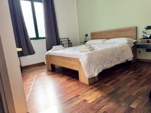 a bedroom with a bed and a wooden floor at Dormire a Reggio zona Aeroporto in Reggio di Calabria