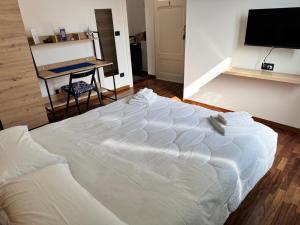 a large white bed in a room with a table at Dormire a Reggio zona Aeroporto in Reggio di Calabria