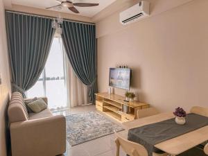 a living room with a couch and a table and a tv at NonaHome 1 bedroom Nilai in Nilai