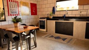 a kitchen with a wooden table and a counter top at Casa Espaço Pérola in Rio das Ostras +11 photos