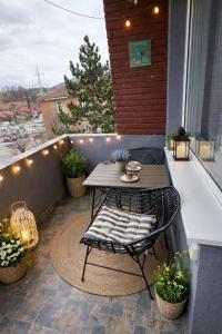 a patio with a table and chairs on a balcony at Delux Flat Straja in Lupeni
