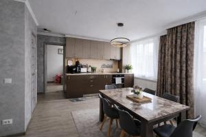 a kitchen and dining room with a table and chairs at Delux Flat Straja in Lupeni