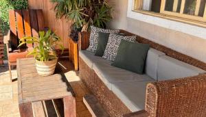 a bench with pillows and a table on a patio at Casa Espaço Pérola in Rio das Ostras