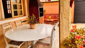 a white table and chairs on a patio at Casa Espaço Pérola in Rio das Ostras