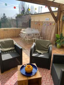 eine Terrasse mit zwei Stühlen und einem Tisch auf einem Deck in der Unterkunft Maison IDEM in Vouziers