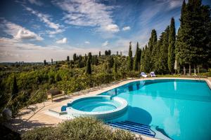 a large blue swimming pool with a view of trees at Borgo Bucciano in San Miniato