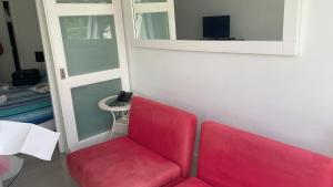 a red chair in a room with a mirror at Green Park Solanas Monoambiente Punta del Este in Punta del Este