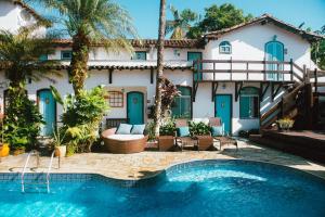 a house with a swimming pool in front of a building at Casa Aldeia Paraty in Paraty