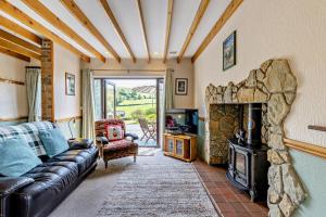 a living room with a couch and a stone fireplace at 2 Bed in Aberystwyth oc-99869 in Devils Bridge