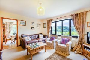 a living room with a couch and a table at 4 Bed in Tywyn oc-23385 in Llanfihangel-y-Pennant