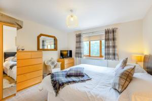 a bedroom with a white bed and a mirror at 4 Bed in Tywyn oc-23385 in Llanfihangel-y-Pennant