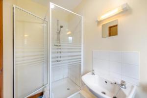 a white bathroom with a shower and a sink at 4 Bed in Tywyn oc-23385 in Llanfihangel-y-Pennant +30 photos