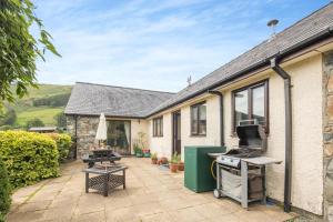 a house with a patio with a stove and a grill at 4 Bed in Tywyn oc-23385 in Llanfihangel-y-Pennant