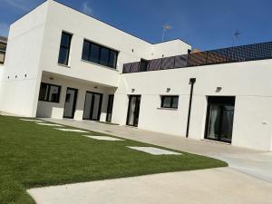 a white house with a green lawn in front of it at Búnker de Pepa in Zamora