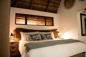 a bedroom with a large white bed with two pillows at LittleBush Private Lodge in Hoedspruit