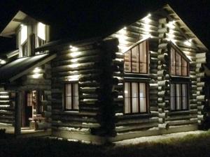 a log cabin with lights on the facade at night at Runoilevi B3 Visit Levi in Sirkka