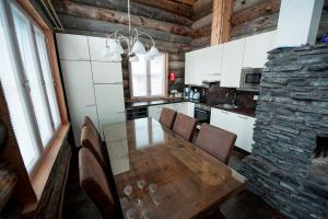 a kitchen with a wooden table and a stone wall at Runoilevi B3 Visit Levi in Sirkka