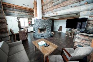 a living room with a fireplace and a table at Runoilevi B3 Visit Levi in Sirkka