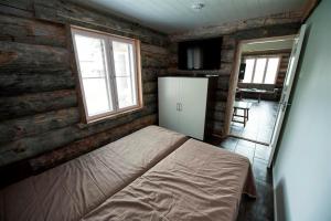 a small bedroom with a bed and a refrigerator at Runoilevi B3 Visit Levi in Sirkka +1 photo