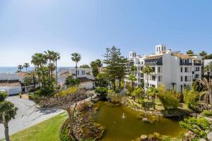 an aerial view of a apartment complex with a pond at Jardines de las Golondrinas in Marbella