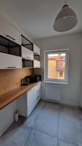 a kitchen with white cabinets and a large window at Apartament Bellissima in Bielsko-Biała