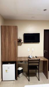 a room with a desk with a tv and a desk sidx sidx sidx at Moda Center Hotel in Santa Cruz do Capibaribe