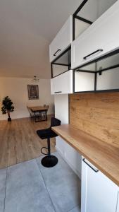 a kitchen with white cabinets and a table with a chair at Apartament Bellissima in Bielsko-Biała