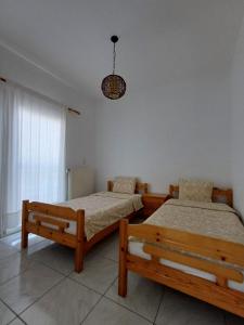 a bedroom with two beds and a chandelier at Vassilikos Apartment in Flogita