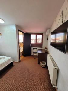a bedroom with a bed and a desk and a bathroom at MAG Motel in Bucharest