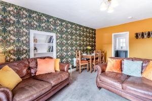 a living room with two leather couches and a table at 2 Bed in Staffield oc-j32453 in Kirkoswald