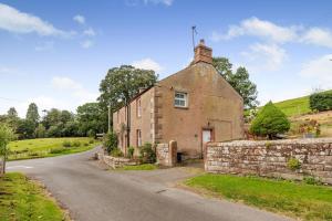 an old house on a road with a stone wall at 2 Bed in Staffield oc-j32453 in Kirkoswald