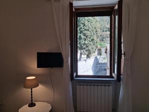 a room with a window with a lamp and a radiator at Civico 10 in Gubbio
