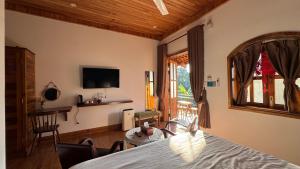 a living room with a television and a table and chairs at Hoàng Doji de Villa in Thôn Dương Xuân Hạ