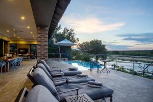 a patio with several couches and a swimming pool at Buffalo Brooke in Hectorspruit