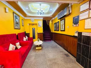 a waiting room with a red couch and a staircase at Bab Al Bahrain Hotel in Manama