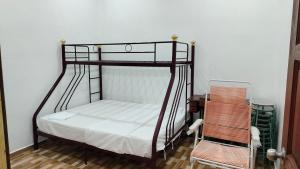 a bedroom with a bunk bed and a chair at Seetha's Homestay in Lunas