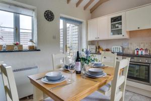 a kitchen with a wooden table and white cabinets at 2 Bed in Llanmadoc oc-hh469 in Llanmadoc