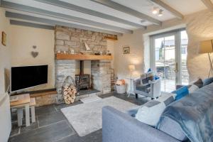 a living room with a couch and a stone fireplace at 2 Bed in Llanmadoc oc-hh469 in Llanmadoc