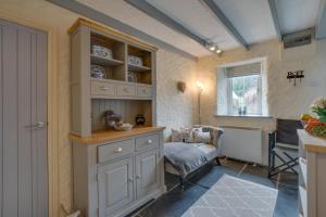 a kitchen with white cabinets and a chair and a window at 2 Bed in Llanmadoc oc-hh469 in Llanmadoc