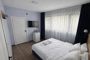 a bedroom with a white bed and a window at ATAKORU Suit in Alacaatlı