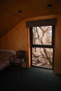 a room with a window with a chair and a bed at Chateau Chapiteau in Gudzhareti