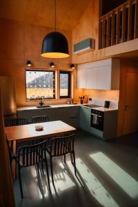 a kitchen with a wooden table and chairs and a sink at Chateau Chapiteau in Gudzhareti