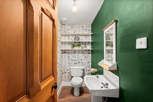 a green bathroom with a toilet and a sink at 6 Howard Place in St. Andrews +27 photos