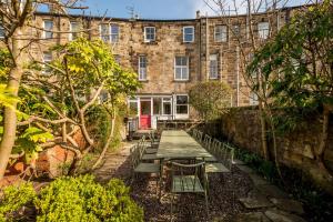 a garden with a table and benches in front of a building at 6 Howard Place in St. Andrews