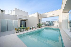 a swimming pool in a house with a table and chairs at Daegu Hyeonpung Prana Hotel in Daegu