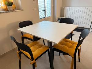 a dining room table with yellow cushions and chairs at Vittorio city apartment, Milano, Centro in Melzo +21 photos